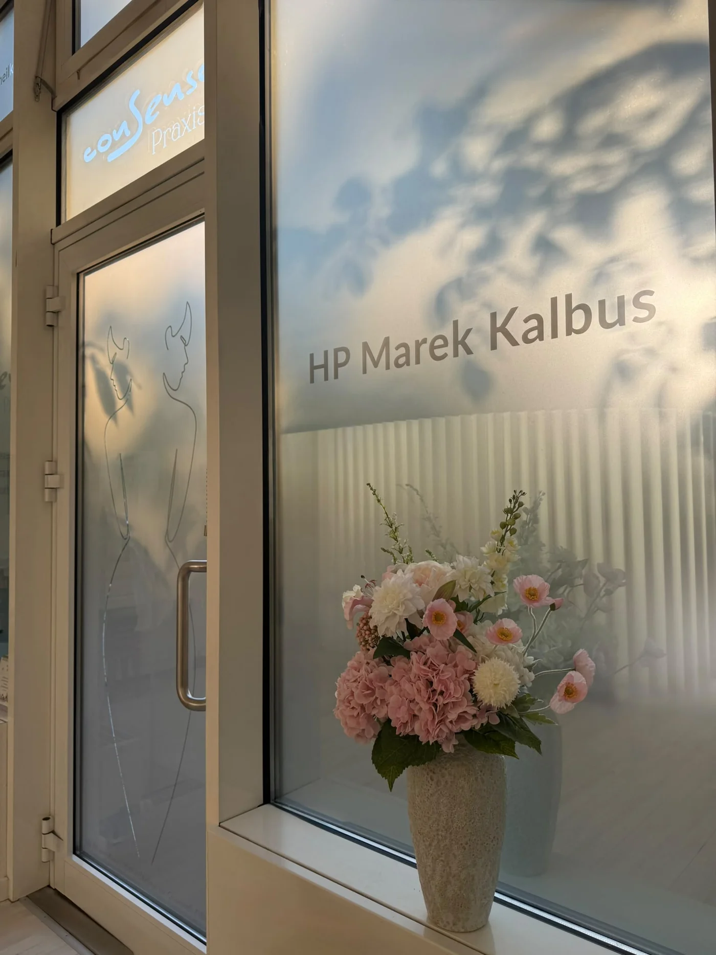 Eingangsbereich der conSenso Praxis 1 in Berlin-Wilmersdorf mit dem Namen Marek Kalbus und Blumen